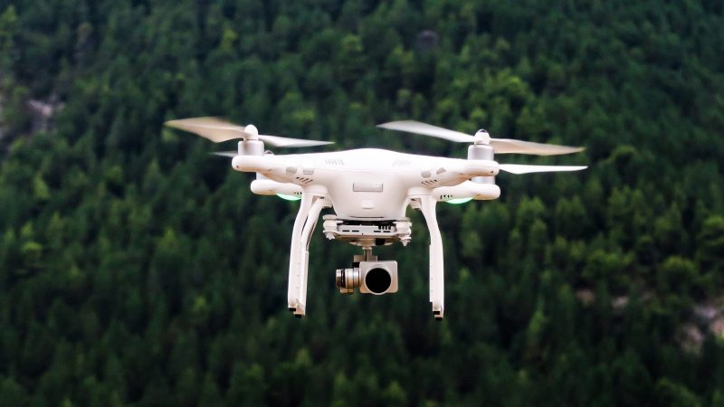 drone hovering over forest in park
